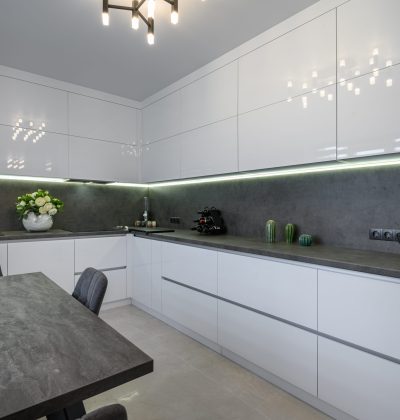 Luxurious modern trendy white and grey kitchen interior after renovation, with granite counter top